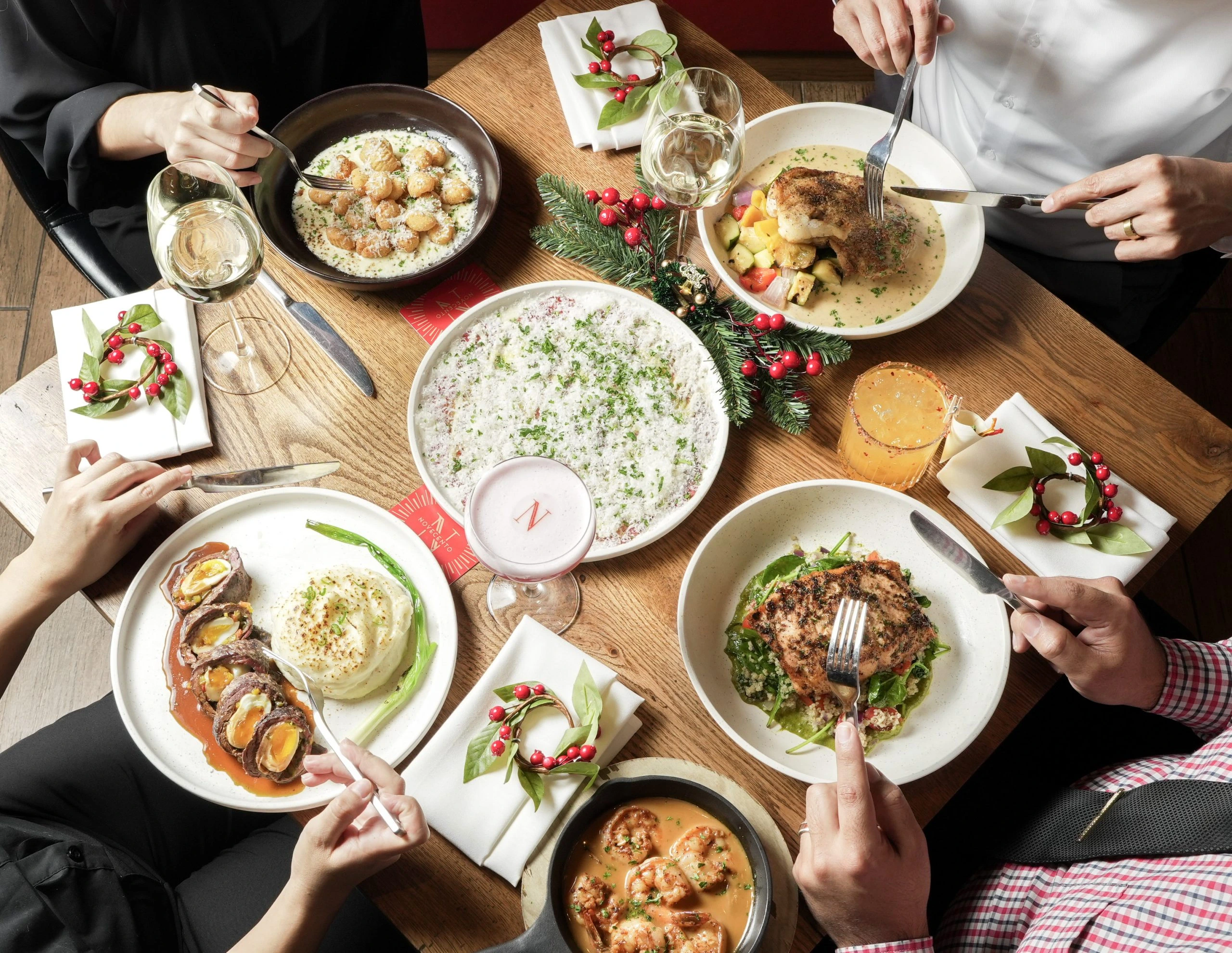 Friends sharing a spread of Novecento dishes
